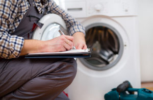 A repairman services a dryer